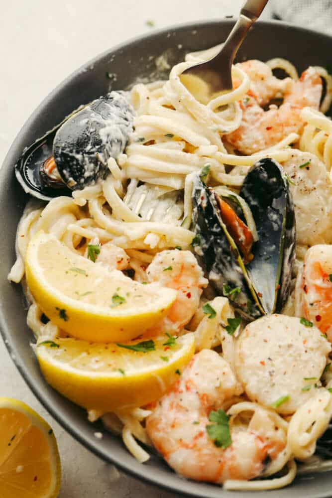 Seafood pasta in a bowl with a fork in the bowl.
