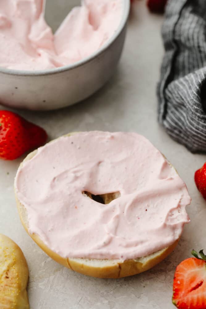 This strawberry cream cheese is rich, creamy, and full of delicious flavor! It's simple to make and will have all of your breakfast bagels tasting SOO GOOD! Strawberry cream cheese on a bagel.