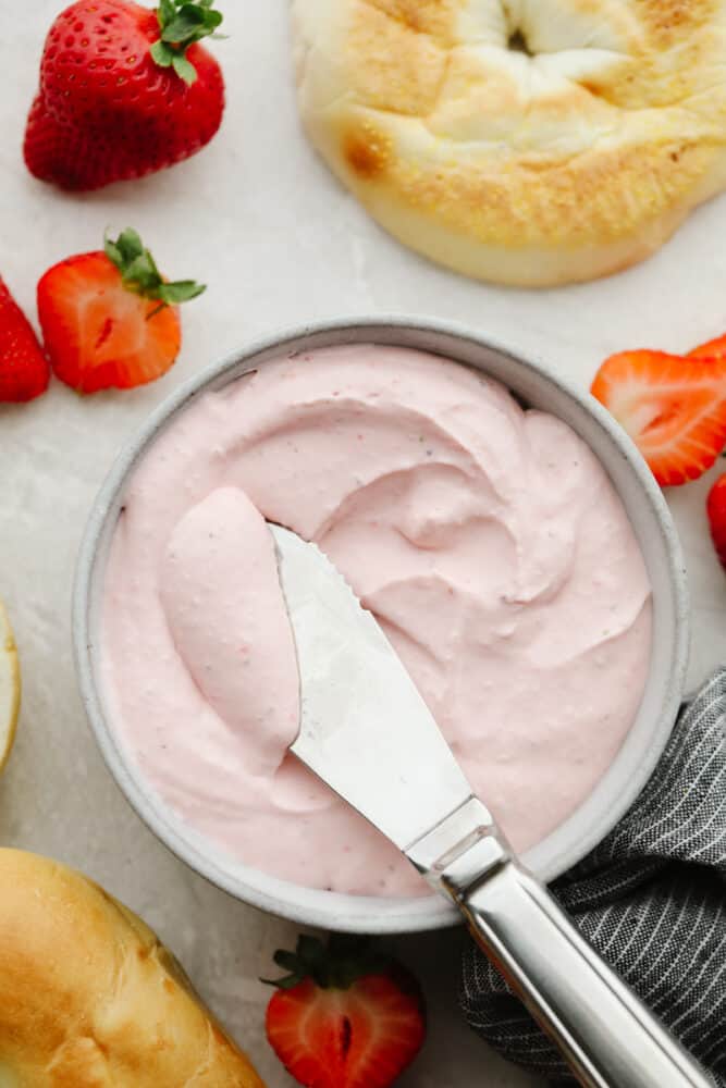 This strawberry cream cheese is rich, creamy, and full of delicious flavor! It's simple to make and will have all of your breakfast bagels tasting SOO GOOD! Strawberry cream cheese in a bowl with a butter knife.